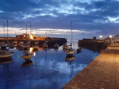 a group of boats docked in a harbor at night at The Snug in Aberaeron