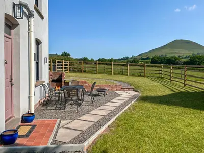 a patio with a table and chairs and a fence at Gwrlodde in Talgarth