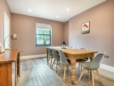 a dining room with a wooden table and chairs at Gwrlodde in Talgarth
