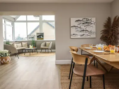 a dining room and living room with a table and chairs at Bryn Hafod in Dyffryn