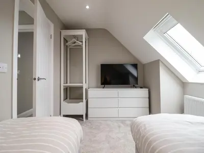 a white bedroom with a tv and a bed at Bryn Hafod in Dyffryn