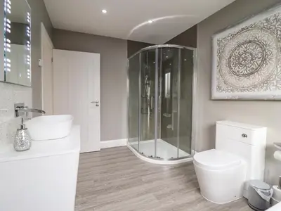 a bathroom with a shower and two sinks and a toilet at Bryn Hafod in Dyffryn