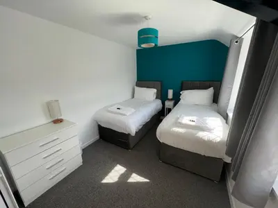 a small room with two beds and a dresser at Escapism Wales Garthowen in Llanrhystyd
