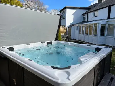 a hot tub on the back of a house at Escapism Wales Garthowen in Llanrhystyd