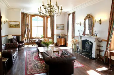 a living room with leather furniture and a fireplace at The Buckley Arms in Dinas Mawddwy