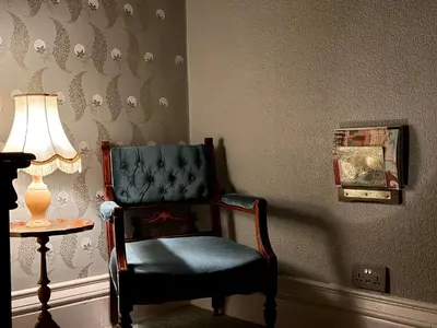 a blue chair in a room with a lamp at The Buckley Arms in Dinas Mawddwy