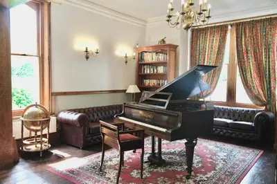 a living room with a piano and a couch at The Buckley Arms in Dinas Mawddwy