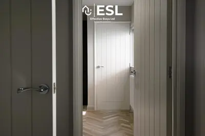 a hallway with a white door with a sign on it at Comfy Modern 2 Bedroom Duplex Apartment with Sun Terrace in Shrewsbury
