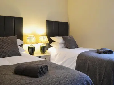 two beds in a room with two lamps and two beds sidx sidx sidx at Seascape in Aberystwyth