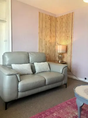 a leather couch in a living room with a lamp at Cranwell Court Apartments in Aberystwyth