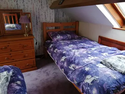 a bedroom with a bed and a dresser and a window at 1 Park Terrace in Corris