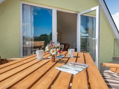 a wooden table with flowers on a balcony with a window at Penceunant in Penuwch