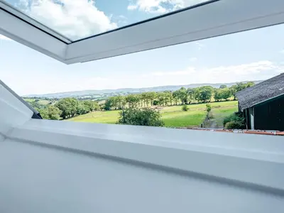 a window in a house with a view of the countryside at Penceunant in Penuwch