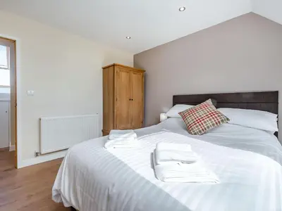 a bedroom with a white bed with two towels on it at Penceunant in Penuwch