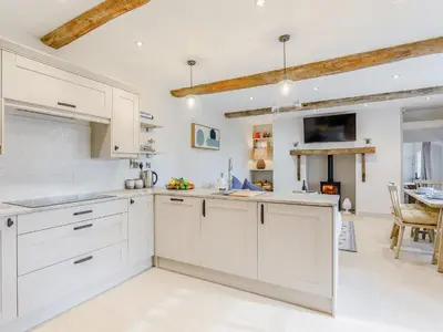 a white kitchen with white cabinets and a table at Little Whitley - Uk38099 in Great Hanwood