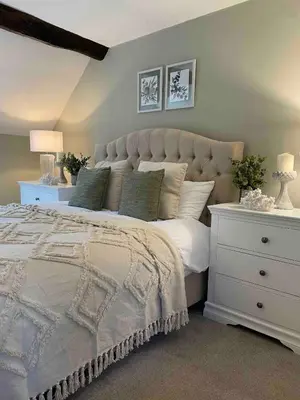 a bedroom with a large bed and a white dresser at Penddol Cottage Llangollen in Llangollen
