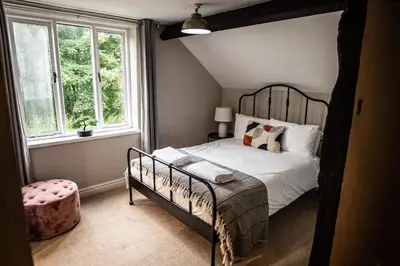 a bedroom with a bed and a large window at Penddol Cottage Llangollen in Llangollen