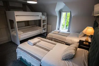a bedroom with two bunk beds and a window at Penddol Cottage Llangollen in Llangollen