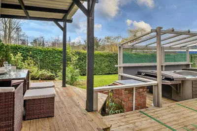an outdoor patio with a grill and a pergola at Finest Retreats - Garden Lodge in Craven Arms