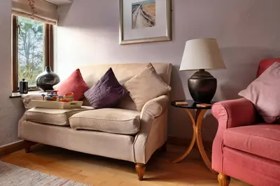 a living room with a couch and a lamp at Finest Retreats - Dolwar Cottage in Ffestiniog