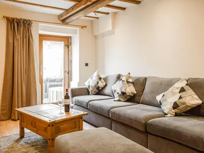 a living room with a couch and a coffee table at Wheelwright Cottage in Clunbury