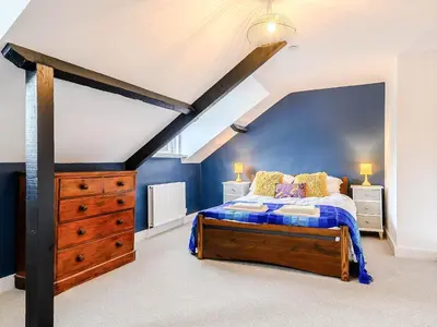 a bedroom with a bed and a blue wall at Ty Afon in Talybont