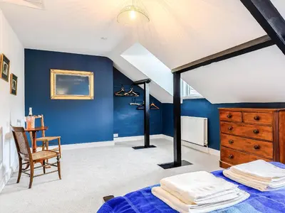 a bedroom with blue walls and a bed and a chair at Ty Afon in Talybont