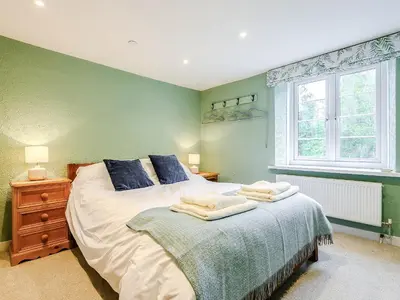 a bedroom with a large bed and a window at Ty Afon in Talybont