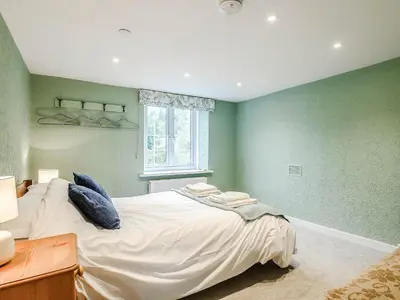 a bedroom with a large bed with green walls at Ty Afon in Talybont