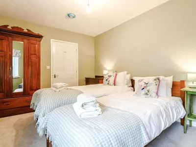 a bedroom with two beds with white sheets at Ty Afon in Talybont