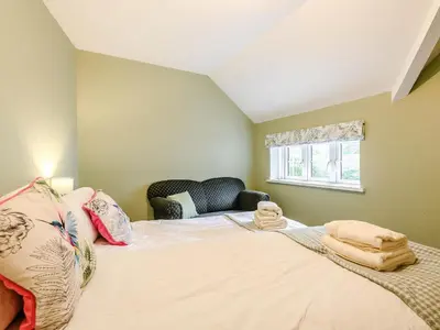 a bedroom with a large bed and a window at Ty Afon in Talybont