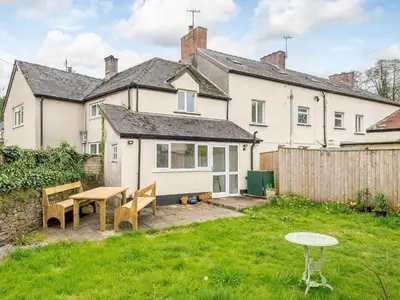 a house with a table and chairs in a yard at Ty Afon in Talybont
