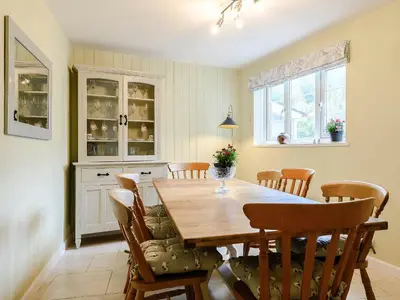 a dining room with a wooden table and chairs at Ty Afon in Talybont