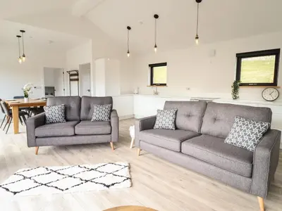 a living room with two couches and a table at The Sheep Shed in Oswestry