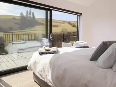 a bedroom with a bed and a large window at The Sheep Shed in Oswestry