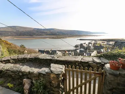 a stone fire pit with a view of the water at 2 Bwth Mawr in Barmouth