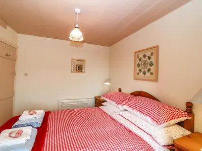 a bedroom with two beds with red and white sheets at 2 Bwth Mawr in Barmouth