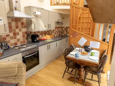 a kitchen with a table and chairs in a kitchen at A unique and cosy cottage - optional hot tub - Pass the Keys in Church Stretton