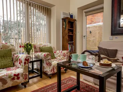 a living room with chairs and a table with food on it at A unique and cosy cottage - optional hot tub - Pass the Keys in Church Stretton