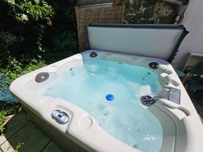 a jacuzzi tub sitting in a yard at A unique and cosy cottage - optional hot tub - Pass the Keys in Church Stretton