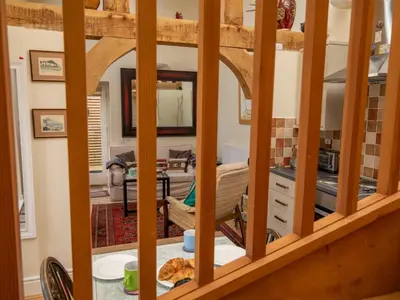 a view of a kitchen from the living room through a mirror at A unique and cosy cottage - optional hot tub - Pass the Keys in Church Stretton