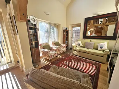 a living room with a couch and chairs in it at A unique and cosy cottage - optional hot tub - Pass the Keys in Church Stretton