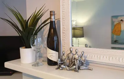 a bottle of wine sitting on a table next to a glass at Central cosy home 5 minutes walk from Shrewsbury - Pass the Keys in Shrewsbury