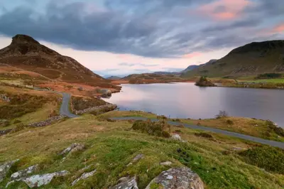 a lake in the middle of a mountain with a road at 1 Bed in Dolgellau oc-bow283 in Trawsfynydd