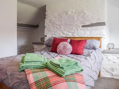 a bed with blankets and pillows on top of it at Blaen Y Cwm in Carno