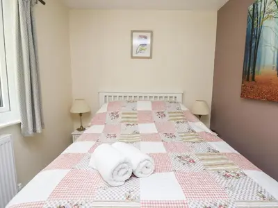 a bedroom with a bed with towels on it at Honeysuckle Cottage in Llandrindod Wells