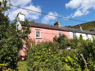 a red and white house with trees in front of it at Rhandirmwyn - Cottage - Sleeps 4 - Pet Friendly in Llandovery