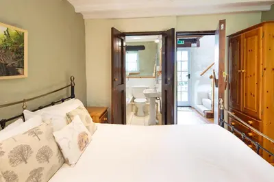 a bedroom with a bed and a bathroom at Brynarth Country Cottages in Aberystwyth