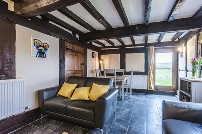 a living room with a couch and a table at River Cottage, Melverley in Melverley