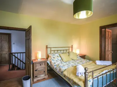 a bedroom with a bed and two lamps and a staircase at Home Farm House in Dorrington